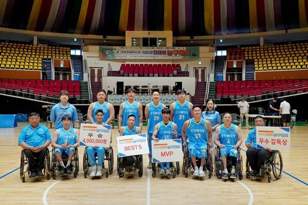Players and officials of the Coway Blue Wheels pose for a group photo after winning the 13th Jeju Special Self-Governing Province Governor's Cup International Invitational Wheelchair Basketball Tournament at Jeju Halla Gymnasium on July 20. (Photo: Coway)