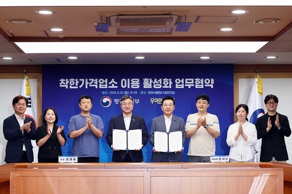 Officials from Woowa Brothers and the Ministry of the Interior and Safety pose for a commemorative photograph after signing an agreement to promote the use of Good Price Stores. (Photo: Woowa Brothers)