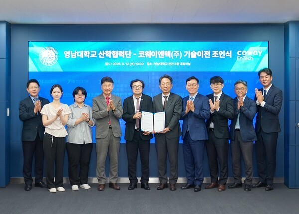 Bang Yun-hyuk, CEO of Coway Entec (fifth from right), and Kim Jae-hong, head of the Industry-Academia Research Office at Yeungnam University (fifth from left), pose with other officials at a technology transfer agreement ceremony held August 12 at Yeungnam University in Gyeongsan, Gyeongsangbuk-do, South Korea. (Photo: Coway Entec)