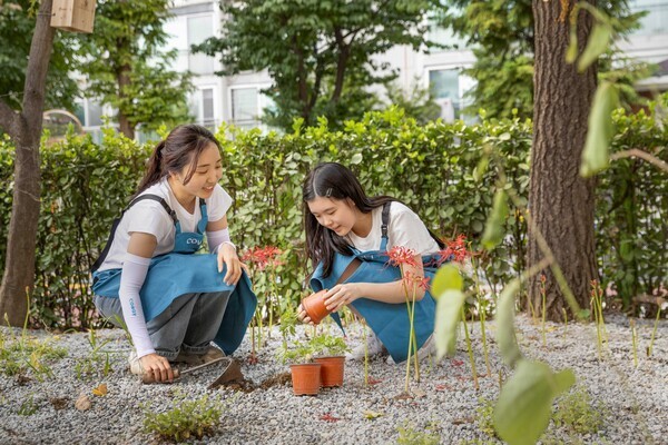 Coway employees and Gyeongil Elementary School students plant vegetation in the third Coway Ecological Forest. (Photo: Coway)